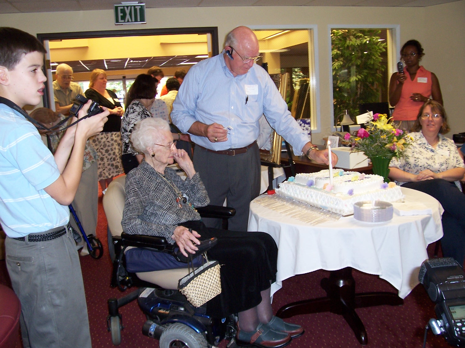 Ed Cone lighting candle on Virgie Cone's 100th birthday cake